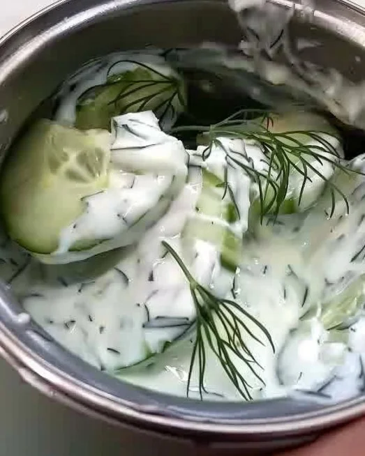 Creamy cucumber salad with fresh ingredients served in a bowl.