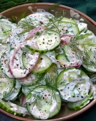 Cucumber salad with Greek yogurt dressing served in a bowl.