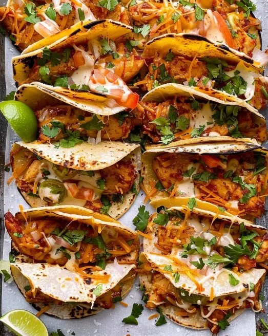 Mini baked chicken tacos served on a plate with fresh toppings.