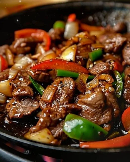 Sizzling Chinese Pepper Steak with Onions 2 Sizzling Chinese pepper steak with onions served on a plate