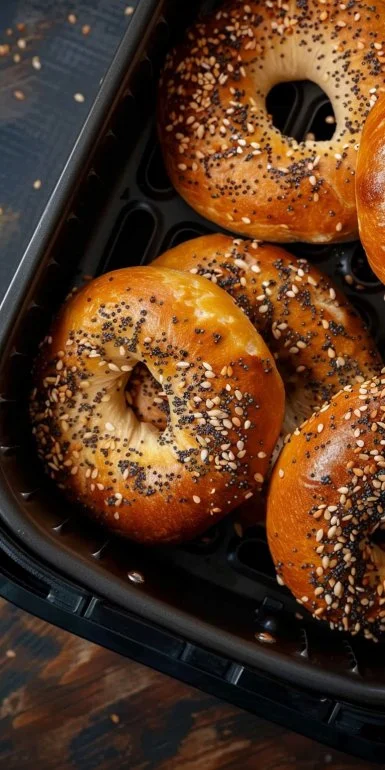 Homemade Air Fryer Bagels garnished with sesame seeds on a wooden table